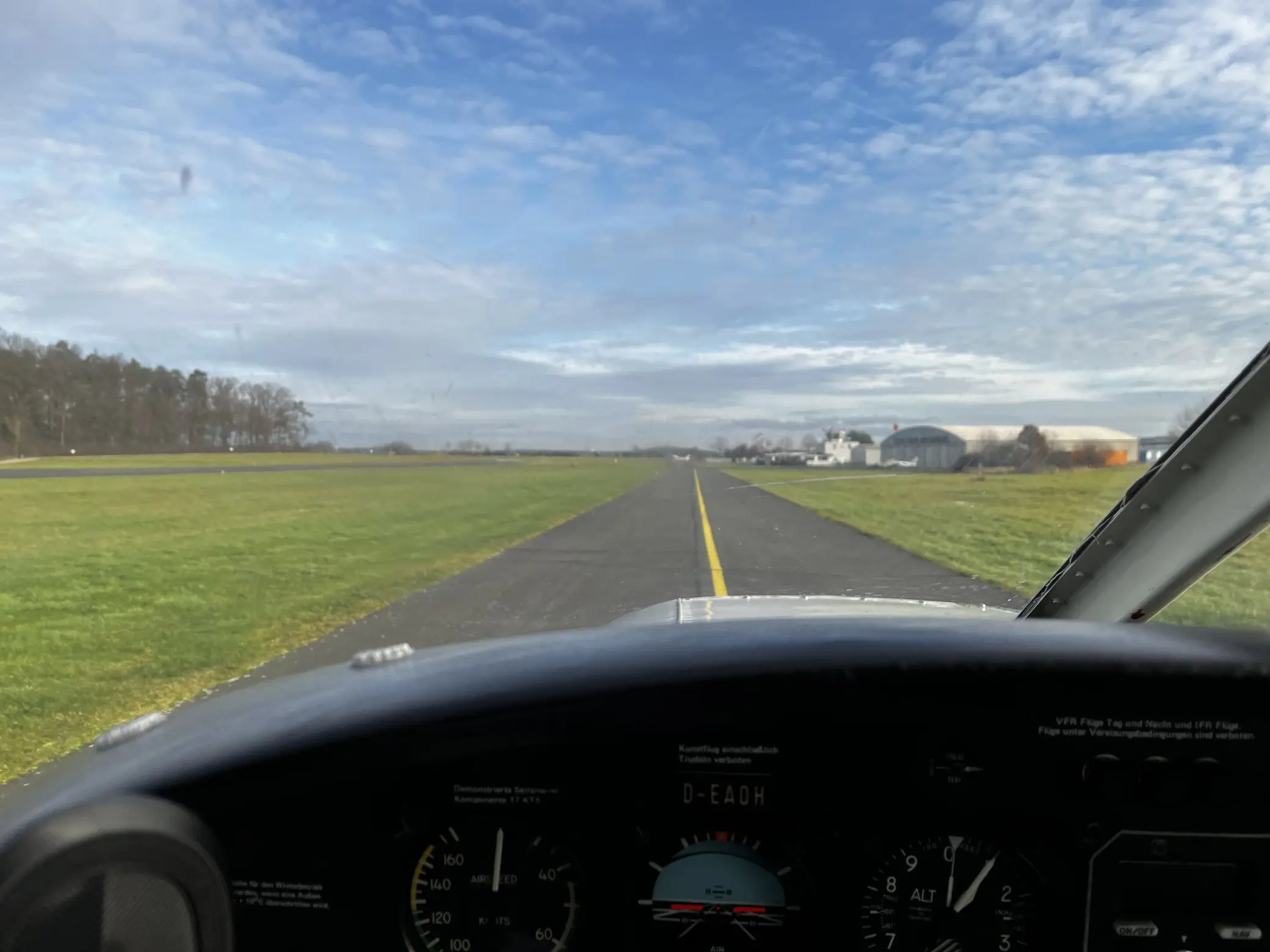 Blick aus dem Cockpit über das Instrumentenbrett auf die leere Startbahn voraus
